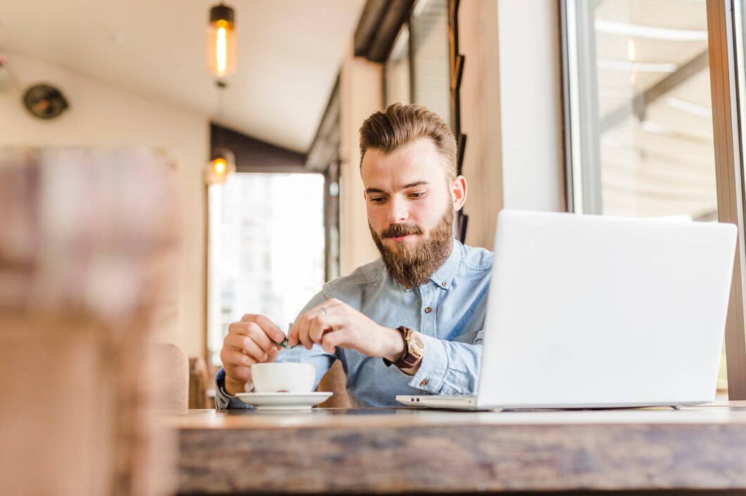 Man working on his laptop in a cafe while connected to the cafe’s public network